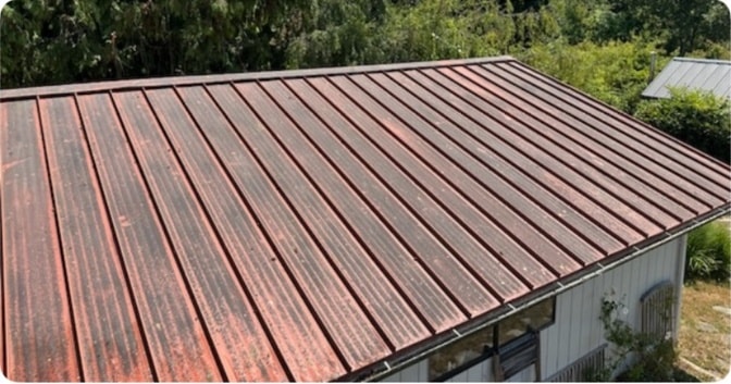 Metal roof before professional soft wash cleaning — moss and organic staining visible